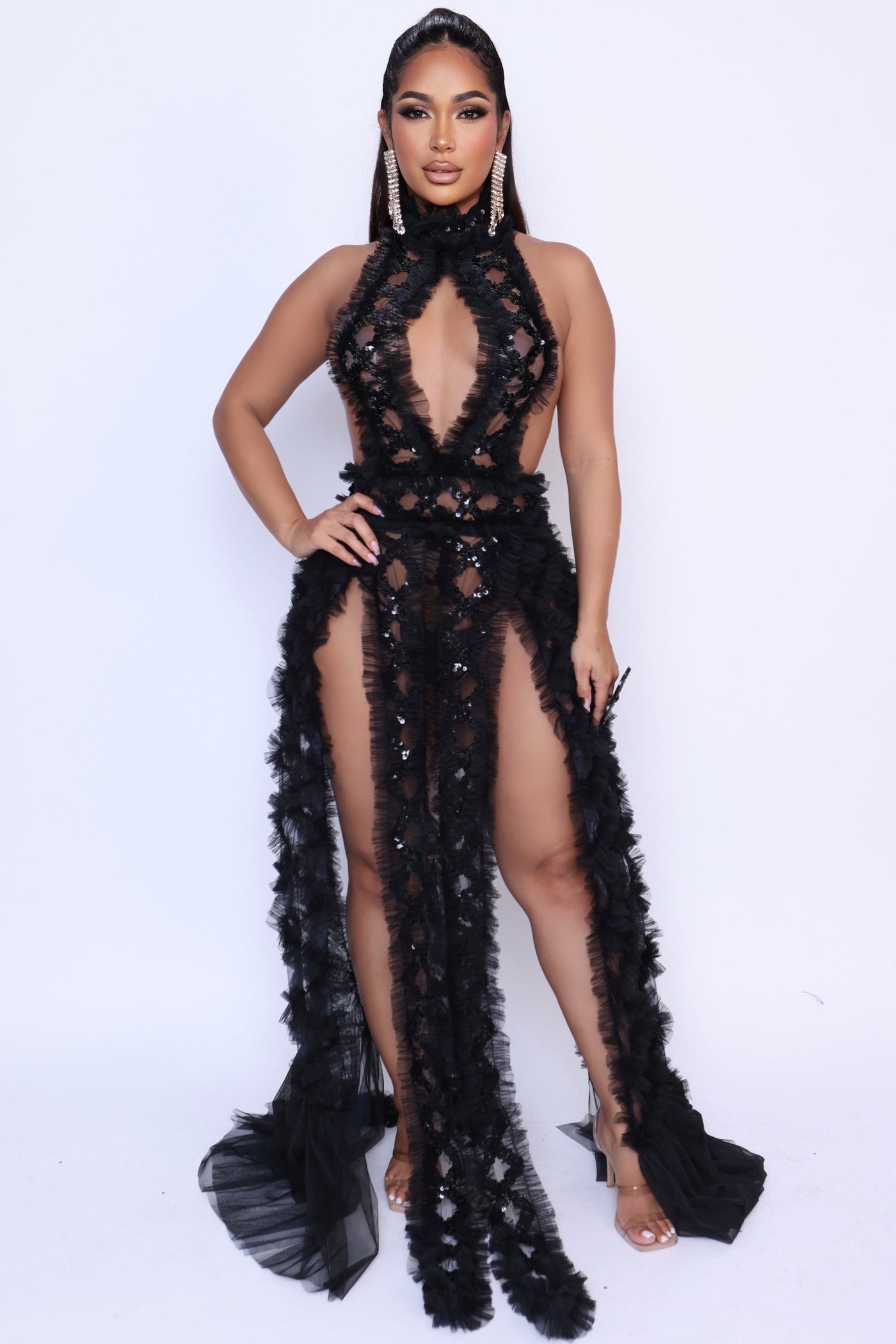 Model wearing black Lovers & Friends gown with bold V neckline, sequin mesh, and tiered ruffle accents for maximum drama.