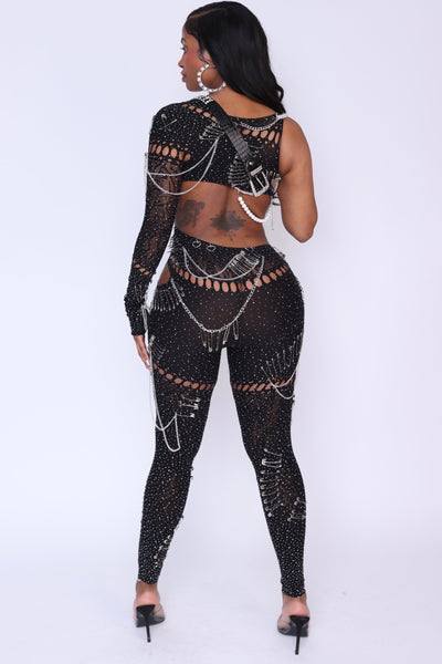 Back view of the Risque Affair Cutout Mesh Jumpsuit with edgy slashes and exposed hip.