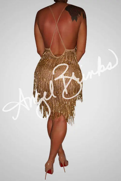 Open back with crisscross straps, showcasing the shimmering gold fringe detail along the hem and bodice.