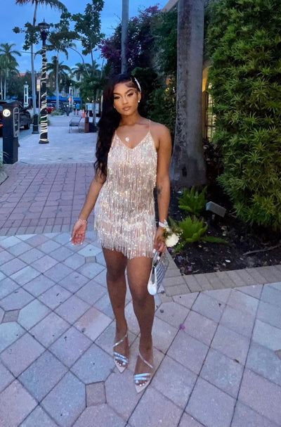 Front view of model wearing Stadium Status gold mesh mini dress with plunging V neckline and fringe rhinestone detail.
